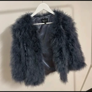 Grå pälsjacka från NC - Säljer en supermjuk och fluffig grå pälsjacka från natures collection. Perfekt för att hålla sig varm och snygg under kyliga kvällar. Jackan har en lyxig känsla och är i mycket bra skick, i princip ny. Den är långärmad och passar perfekt för höst och vinter. Perfekt för en utekväll eller fest!