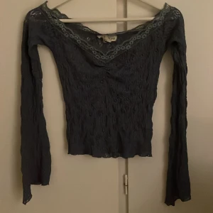 Blå spetsblus från Urban outfitters  - Säljer en superfin blå spetsblus från Urban outfitters. Den har en vacker v-ringning och långa ärmar. Den passar även som off shoulder. Har bara använts 1 gång.