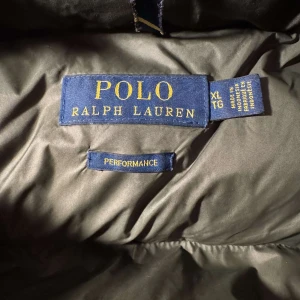 Polo Ralph lauren  - Tja, Säljer en grön dunjacka från Polo Ralph Lauren i storlek XL. Men sitter skit bra jag är 182 väger 70. Jackan har en pufferstil med huva och dragkedja framtill. Perfekt för kalla vinterdagar med sin varma och bekväma design. Den är i mycket bra skick och redo för nya äventyr! 🍂❄️