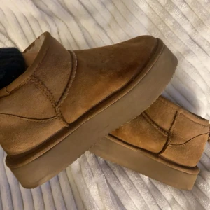 Bruna boots i mocka - Säljer ett par snygga plattå uggs i äkta mocka fodrade med ull. Så jätte varma o bra till vintern🤍 Köptes för 1500kr men säljer för 450 (pris går att diskutera) 💋⭐️ Endast använda en vinter