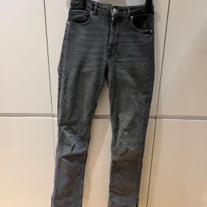 Grå jeans med slits - Zara - Säljer ett par grå jeans i mycket bra skick. De är högmidjade och har en slits nedtill, bootcut.