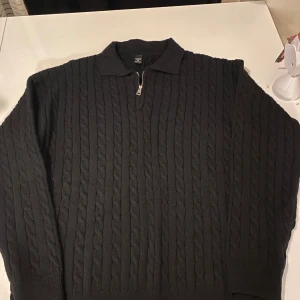 Svart stickad tröja från Manfinity - Säljer en snygg svart stickad tröja från Manfinity. Den har en dragkedja framtill och en klassisk krage. Perfekt för kyliga dagar och passar både till vardags och lite finare tillfällen. Tröjan är i storlek M och är i bra skick.