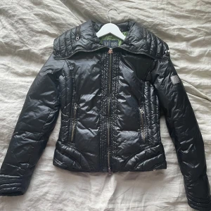 Armani dunjacka - Otroligt snygg dunjacka från Armani. Jackan har 20% fjäder och 80% dun. Storlek motsvarande 38 men skulle säga att den passar S. Mycket bra skick, förutom lite blek på kragen av jackan, se sista bild, knappt märkbar (ser ut som en reflektion). 