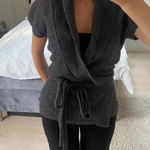 Grå stickad - Grå stickad kortärmad kofta med knytdetalj⭐️⭐️⭐️⭐️