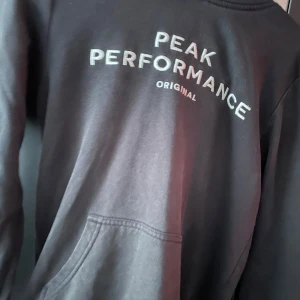 Svart hoodie från Peak Performance - Säljer en svart hoodie från Peak Performance. Säljer då den är för liten, vid frågor och funderingar så är de bara att höra av sig svarar på allt!!