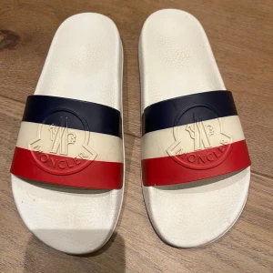 Moncler sliders - Skitcoola Moncler sliders/flip flop. Helt ok skick men absolut fortfarande jättefina❤️‍🔥