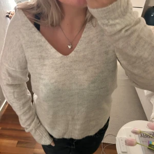 Stickad tröja - Gråmelerad stickad tröja med v-ringning. Från märket JDY köpt på gökaäter. Helt oanvänd lapparna sitter kvar!
