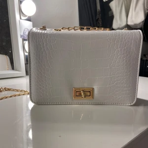 Vit axelremsväska  - Har använt endast en gång. Guldiga Axelremms kedjor. Otroligt söt! Du kan ha den till vad du vill som tex skola eller fest!