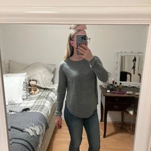 Grå långärmad tröja - Säljer en stilren grå långärmad tröja med rund hals. Perfekt för en avslappnad look och passar bra till jeans. Tröjan har en mjuk och bekväm passform.