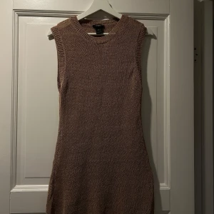 Beige stickad klänning från Lindex - Snygg beige stickad klänning från Lindex i storlek M. Klänningen är ärmlös och har en rund halsringning, perfekt för lager-på-lager eller som den är över tex en bikini. 