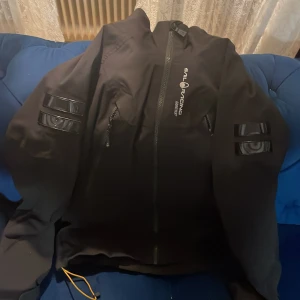 Svart jacka från Sail Racing - Snygg svart jacka från Sail Racing med dragkedja och logotypdetaljer. Perfekt för kyligare dagar med sin stilrena design och funktionella fickor.