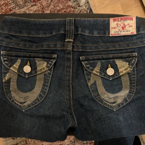 vintage true religion becky - vintage bootcut true religion jeans i modellen becky med cool design på bak fickorna. väldigt lågmidjade. säljer eftersom att de är för små för mig.   Köpt pris är 1200kr,  kan diskutera ifall det behövs. måste bli av med dem akut (pengar kris). hör gärna av er för mer info❤️