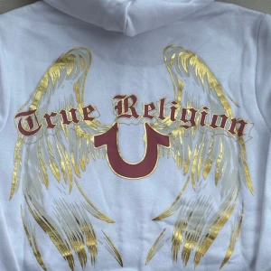 true religion set 🤍 - helt nya vita true religion mjukisbyxor (M) med ett snyggt ängelmotiv i guld och rött på sidan med matchande tjocktröja (XS)!nypris är ca 1700kr för tjocktröjan och 1600kr för mjukisbyxorna! kan sälja var för sig. jag är 176 för referens🤍 har ett vinrött också 🪽
