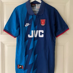 Arsenal retro T-shirts  - Arsenal fotbollströja från Nike med ett coolt blixtmönster i ljusblått. 