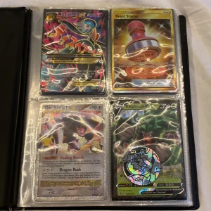 Pokémonkort i samlaralbum - Säljer ett samlaralbum fyllt med olika Pokémonkort, inklusive flera holografiska och EX-kort. Perfekt för samlare eller Pokémon-entusiaster som vill utöka sin samling. Albumet innehåller kort med olika Pokémon och tränarkort. Det är mer kort än dom på bilderna