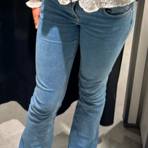 Blå jeans från Zara - Säljer ett par snygga blå jeans från Zara. De har en klassisk bootcut-stil och är perfekta för en avslappnad look. Jeansen är tillverkade i ett bekvämt denim-material och har en låg midja. nypris 400