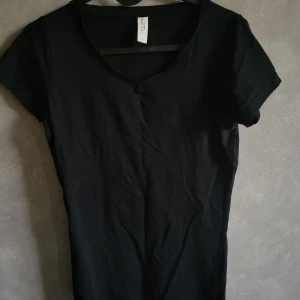 Svart t-shirt från Tee Jays - Snygg svart t-shirt från Tee Jays i storlek S. Den har en klassisk design med korta ärmar och rund hals. Perfekt basplagg för alla tillfällen.