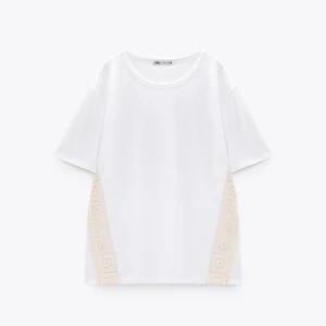 Vit t-shirt med spetsdetaljer från Zara - Snygg vit t-shirt från Zara med korta ärmar och unika spetsdetaljer i beige på sidorna💓