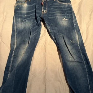 jeans från DSQUARED2 - Snygga blå jeans från DSQUARED2 med slitna detaljer och en klassisk femficksdesign. Jeansen har en normal passform och är perfekta för en avslappnad stil. Märkeslogga på baksidan ger en extra touch.