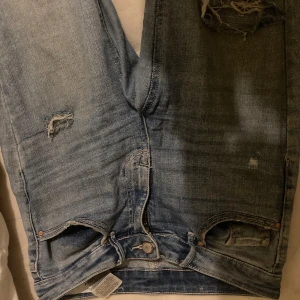 Blå jeans med slitningar - Säljer ett par blå jeans med slitningar och är i en snygg tvättad blå färg. Använda ett par gånger men fina i skicket. Köpte dom för 500 kr så säljer dom nu för 350, hör gärna av er!💕