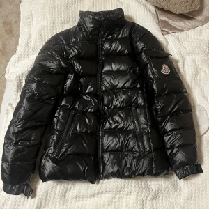 Svart dunjacka från Moncler - Säljer min såå himla fina moncler jacka som är perfekt nu till vintern!! Den sitter verkligen superfint och går att ha både med och utan luva beroende på vad man föredrar. Den ända defekt är att knappen på armfickan är borta men inget man tänker på!! Jag skulle säga att den passar en storlek S! Köpte den för 11000 men kan sälja för 4000 eller 3000 vid snabb affär och kan mötas upp vid de flesta ställen i Stockholm, samt frakta!! Kram💘💘