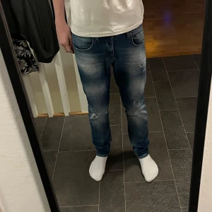 Blå slim fit jeans från Jack & Jones - Snygga blå slim fit jeans från Jack & Jones, modell Slim/Glenn. Jeansen har riktigt snygga slitningar och en riktigt fin färg. Skick 9/10. Modellen är 181 och väger 63.