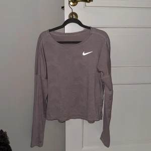 Ljusrosa långärmad tröja från Nike - Säljer en ljusrosa tunnare långärmad tröja från Nike med Dri-FIT teknologi. Perfekt för träning med sin bekväma passform och stilrena design. Tröjan har en diskret mönstring och Nike-logga på bröstet💗🏃‍♀️‍➡️
