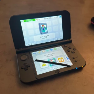 New Nintendo 3DS XL - Säljer ett svart fullt fungerande New Nintendo 3DS XL, i nyare modellen. Man får med tio olika spel, en penna, laddare till konsolen och ett fodral att ha allt i.   Spel som man får med; Mario 3D Land, Super Mario Maker 3DS, New Super Mario Bros 2, Ice Age 4, New Super Mario Bros, Mario Kart 7, The Sims 3, Lego Jurassic World, Imagine Baby Club och Mario Party DS