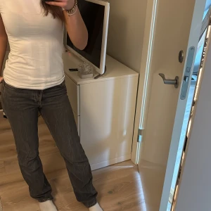 Gråa low waist jeans - Säljer ett par gråa low waist jeans från weekday. Knappt använda och är i ny skick. säljer då de ej kommer till användning. Midjemått:36, innerbenslängd:78