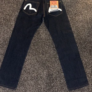 Evisu Jeans - Säljer ett par riktig snygga från jeans från evisu| Dem är helt sprillans nya med alla tags kvar❗️Dessa är i storlek Waist: 32 och Längd: 33| Måtten = bredd: 42 cm/ Längd: 112cm/ Nederkant till gren: 84cm/ ben bredd: 21cm|Nypris är ca 4200kr, mitt pris är 1000kr men ej skrivet i sten| Hör gärna av er vid funderingar 🤗