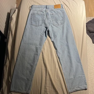 Ljusblå jeans från Jack & Jones - Säljer ett par ljusblå jeans från Jack & Jones i modellen Loose/Eddie. De har en avslappnad passform med klassisk femficksdesign och knappgylf. Perfekta för en casual look. Använd 1 gång. Bara att fråga ifall ni har nått att fråga om!