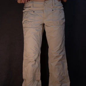 Beige cargobyxor - Snygga beige cargobyxor med flera fickor och knappdetaljer. Byxorna har en loose passform. De är tillverkade i ett slitstarkt material. Använder inte tillräckligt ofta men jag tycker mycket om dem!