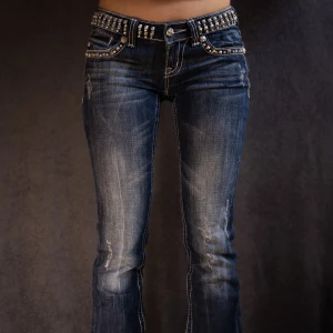 Blå jeans med nitar från Miss Me - Jeans från Miss Me med snyggt glitter och nitar på bältet och bakfickorna. De har en lågmidjad passform och en bootcut-stil. Jag älskar dessa men använder de lite för sällan nu för tiden, bara därför jag säljer!