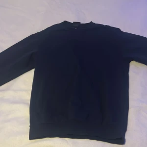 Mörkblå tröja från H&M - Säljer en mörkblå tröja från H&M i relaxed fit. Perfekt för en avslappnad stil. Tröjan har långa ärmar och är gjord i ett mjukt material som känns skönt mot huden.
