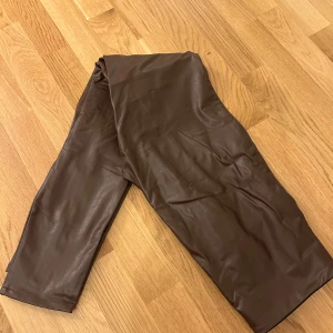 Bruna byxor från Stradivarius - Snygga bruna byxor från Stradivarius i ett läderliknande material. Byxorna har en elastisk midja för extra komfort.