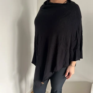 Svart poncho - Snygg och stilren svart poncho perfekt för lager-på-lager-look. Den har en lös passform och är tillverkad i ett mjukt material som ger en skön känsla. Passar utmärkt för både höst och vår🖤