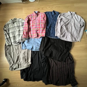 10 olika skjortor i profilen - En samling av skjortor i olika stilar och färger. Inkluderar en rutig skjorta i rött och vitt, en blå skjorta, en beige skjorta och en randig skjorta i bruna nyanser. Perfekt för att variera garderoben med olika mönster och färger.