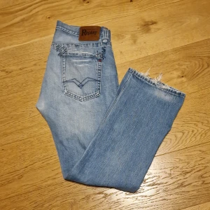 Replay jeans - Snygga ljusblå jeans från Replay med knappar och en cool sliten använd look. De har en normal rak passform och slitna på ett snyggt sätt. Storlek W33/ L32.