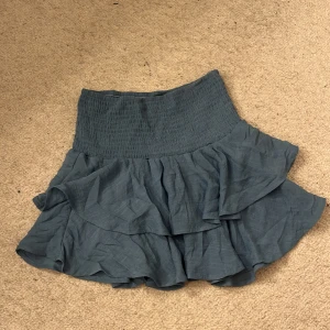 Blå volangkjol från Shein - Snygg blå kortkjol från Shein med volanger. Perfekt för en somrig look. Kjolen har en elastisk midja för extra komfort och stil.