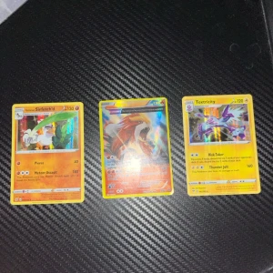 Samling av Pokémonkort - Säljer en samling av Pokémonkort med olika karaktärer som Pikachu, Sirfetch'd och Toxtricity. Inkluderar både vanliga och holografiska kort, samt några EX och V-kort. Perfekt för samlare eller Pokémon-fans!