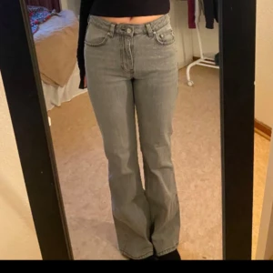 Grå bootcut jeans - Snygga grå bootcut jeans med hög midja. De har klassiska fem fickor och stängs med dragkedja och knapp. De är från Gina!