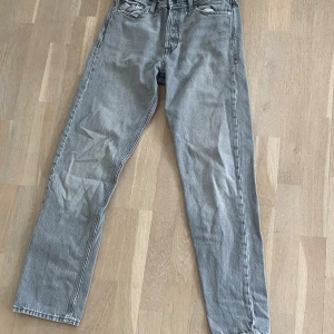 Grå jeansbyxor från jack and Jones  - Snygga grå jeansbyxor med klassisk femficksdesign. De har en rak passform och en bekväm midwaist. Perfekta för en avslappnad stil.