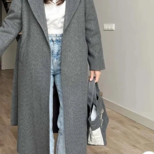 Grå kappa  S - Snygg och stilren grå kappa med lång passform. Perfekt för kyligare dagar och ger en elegant look. Den har långa ärmar och en klassisk krage.