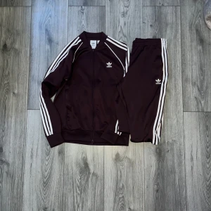 Adiddas tracksuit - Säljer en adiddas tracksuit från Addidas store som jag aldrig använder längre har bara använt den 5 gånger färgen är vinröd 