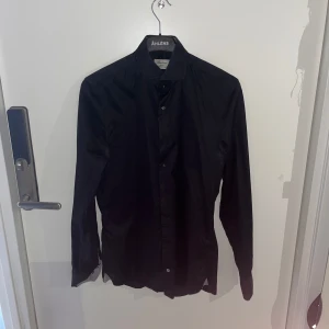 Svart skjorta från Stenströms - Snygg svart skjorta från Stenströms i slim fit. Tillverkad av tvåfaldig super bomull för en lyxig känsla. Perfekt för en stilren look med knappar framtill och klassisk krage. Pris kan diskuteras✅