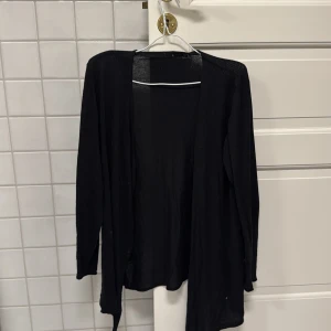 Svart kofta från Åhléns - Säljer en stilren svart kofta från Åhléns i storlek M. Koftan har långa ärmar och är perfekt för lager-på-lager-stil. Den är enkel att matcha med olika outfits och passar till många tillfällen😊