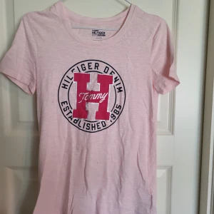 Tommy Hilfiger t-shirt - En rosa Tommy Hilfiger tshirt. Använd fåtal gånger så är i fint skick! Skulle säga att den passar både xxs och xs.