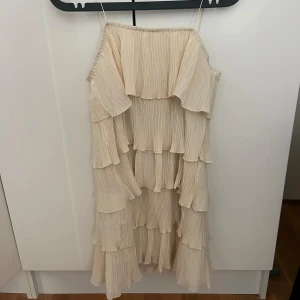 Volangklänning  - Biege Volangklänning, använd en gång 