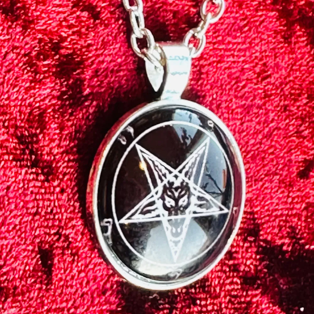 Säljer ett silverfärgat halsband med ett hänge med pentagram i form av Baphomet, även kallad getguden från Mendez. Talismanen som är i svat och vitt är 3,5 x 2,6 cm. Kedjan är cirka 66 cm lång, låses med hummerlås. Vitmetall och glas. Ett ovanligt och mäktigt smycke. Nytt. . Accessoarer.