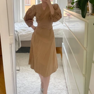 Klänning  - Brun fin wrapklänning med fickor! Bra kvalitet och i nyskick från märket Part Two. Nypris ca 1500, storlek 38 